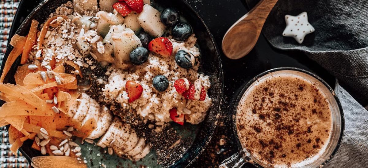 Delicious oatmeal breakfast bowl with fresh fruits and a cup of coffee.