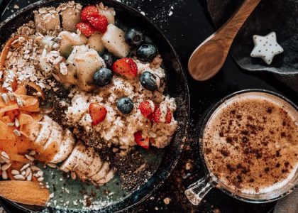 Delicious oatmeal breakfast bowl with fresh fruits and a cup of coffee.